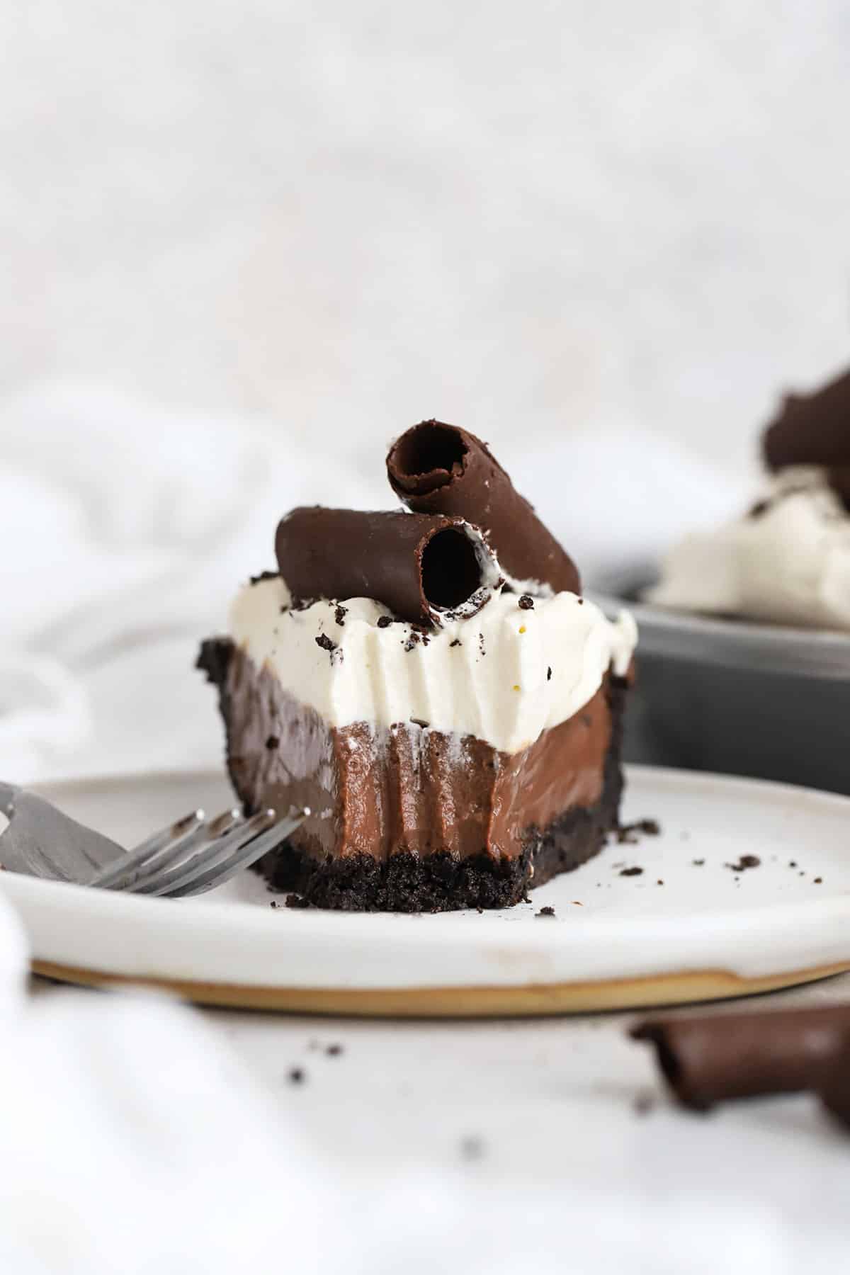 3 layer gluten-free chocolate pie topped with chocolate curls and whipped cream