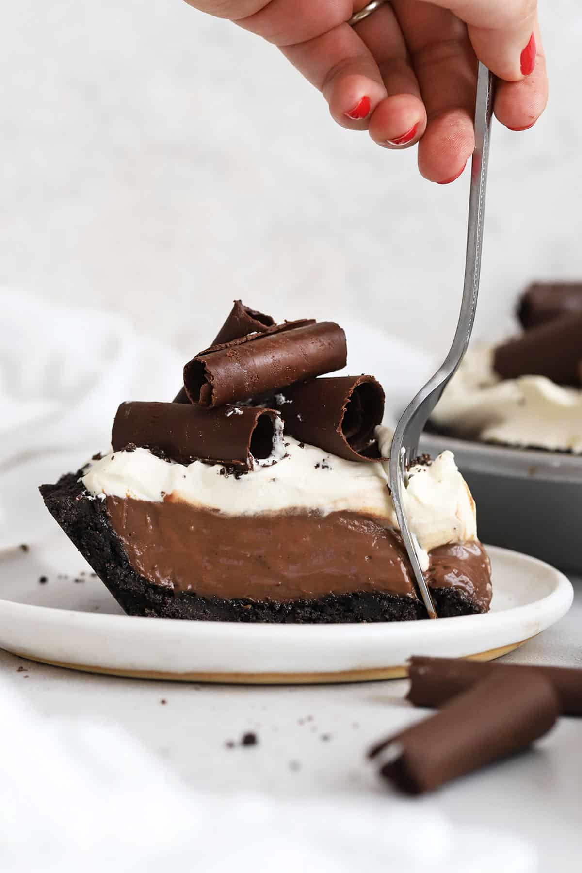 A fork scooping a bite of gluten-free chocolate cream pie