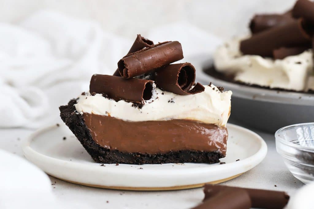 a slice of gluten-free chocolate cream pie topped with whipped cream and chocolate curls