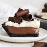 a slice of gluten-free chocolate cream pie topped with whipped cream and chocolate curls