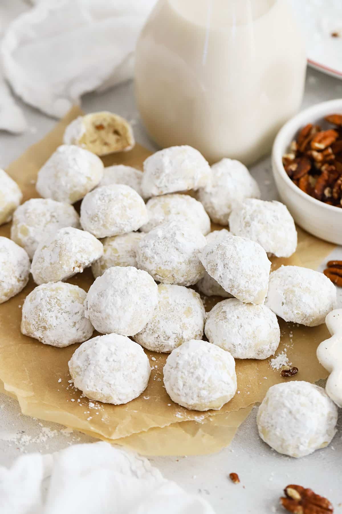 gluten-free snowball cookies on a brown sheet of parchment paper