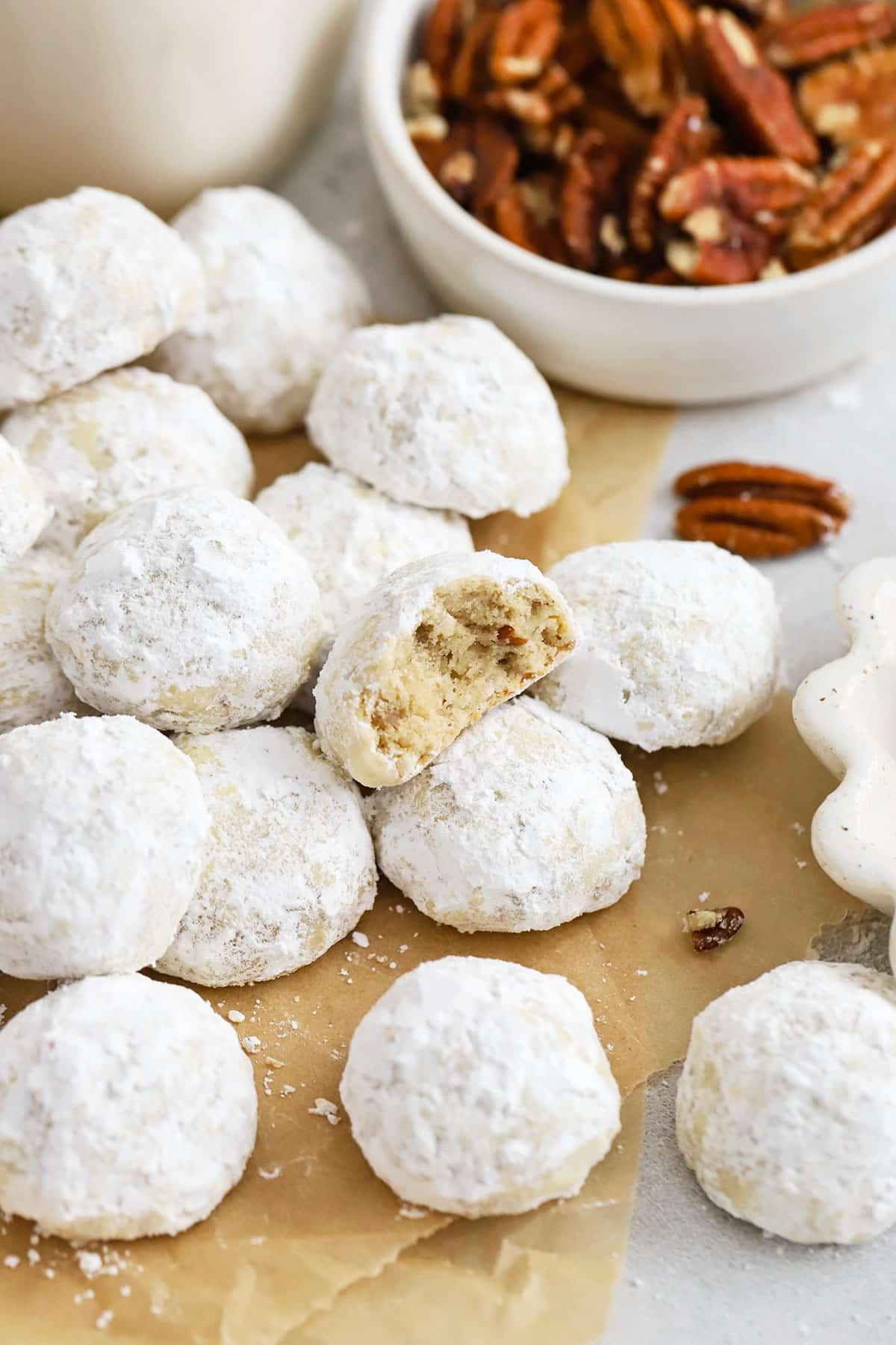 gluten-free snowball cookies on a brown sheet of parchment paper
