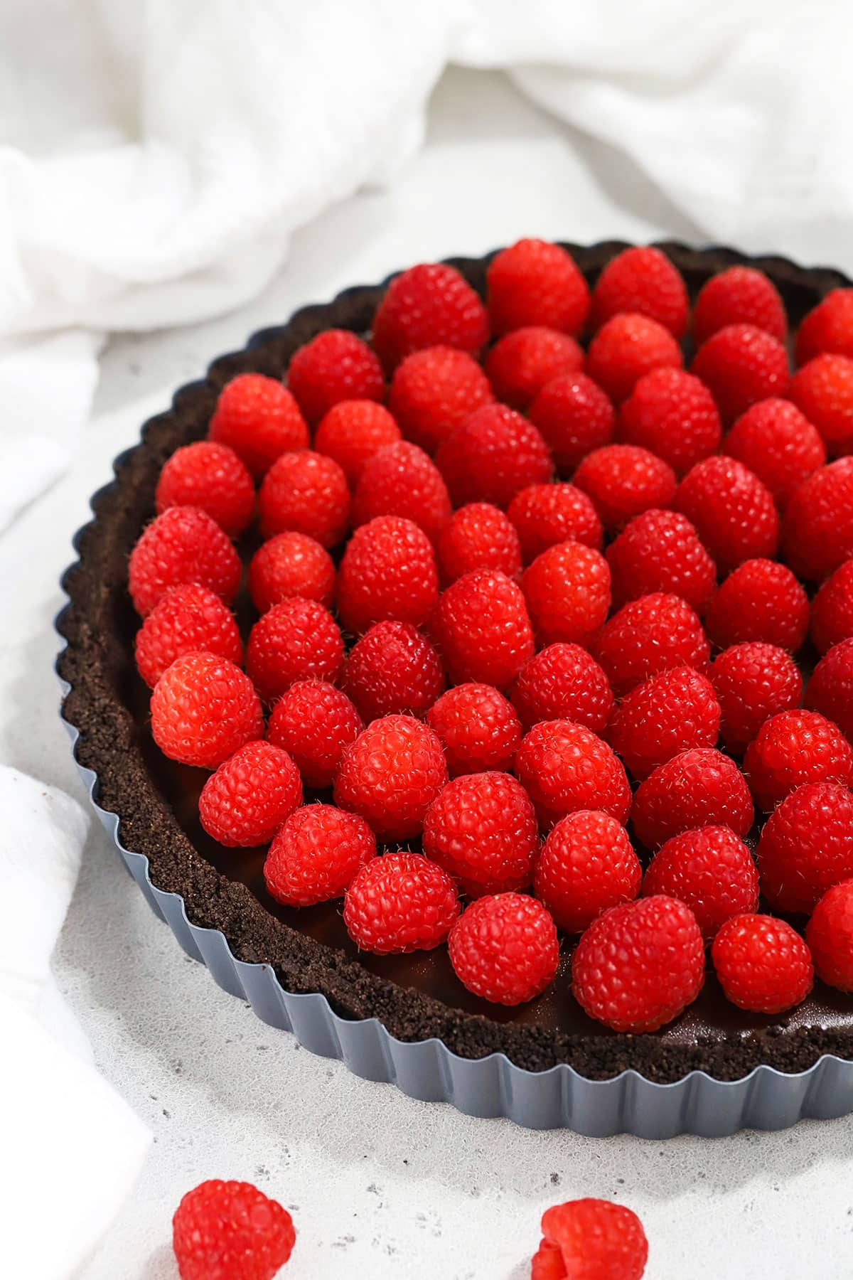 a gluten-free chocolate tart topped with raspberries