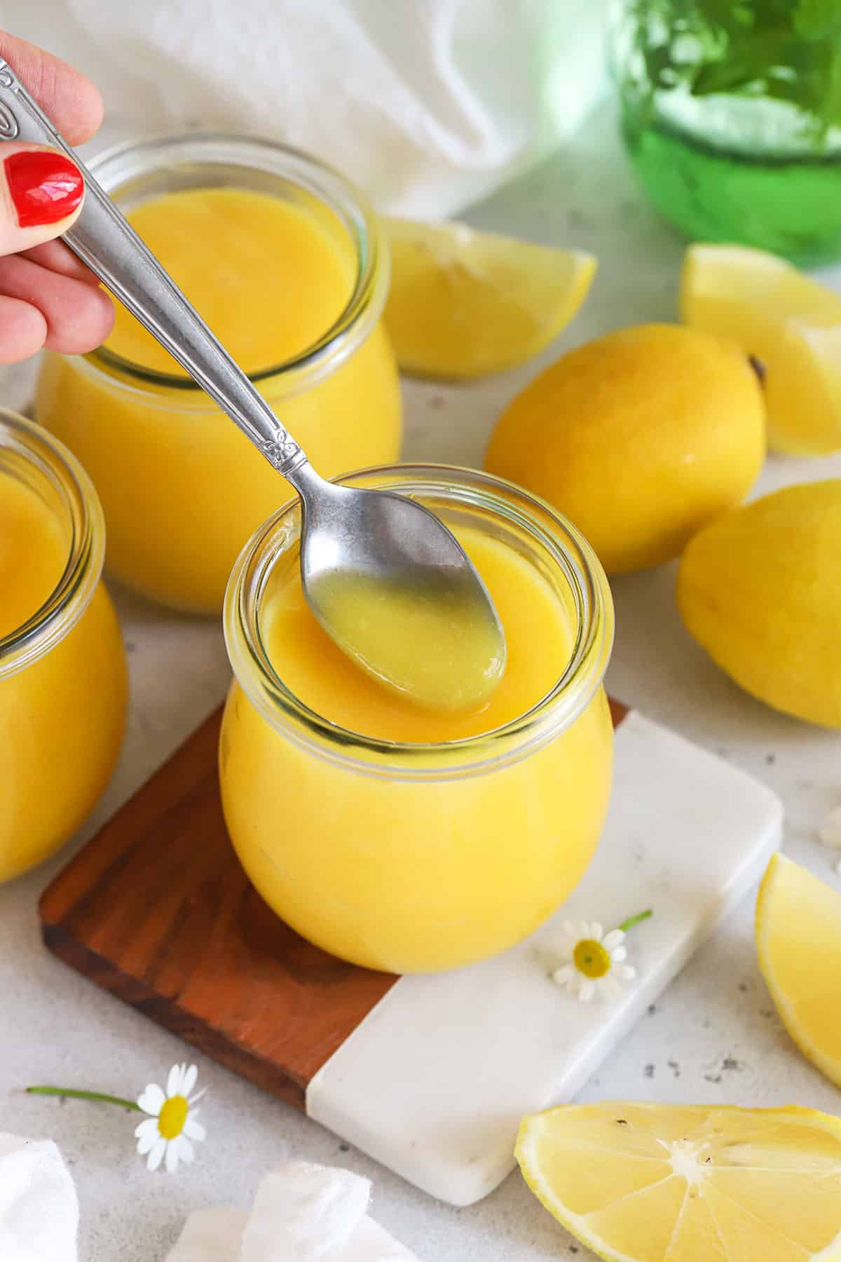 a spoon scooping homemade lemon curd from a jar