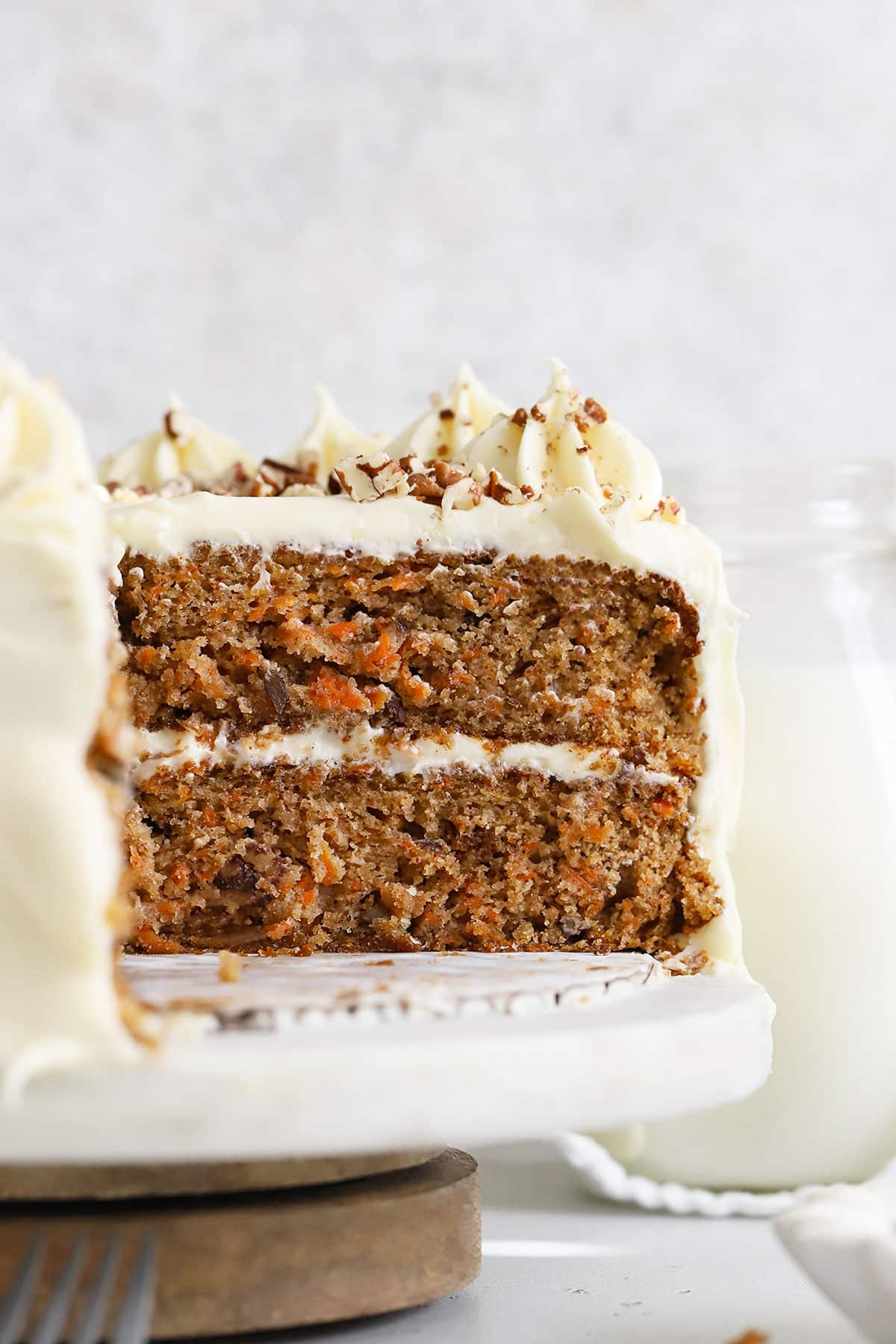 An inside view of a two-layer gluten-free carrot cake with cream cheese frosting