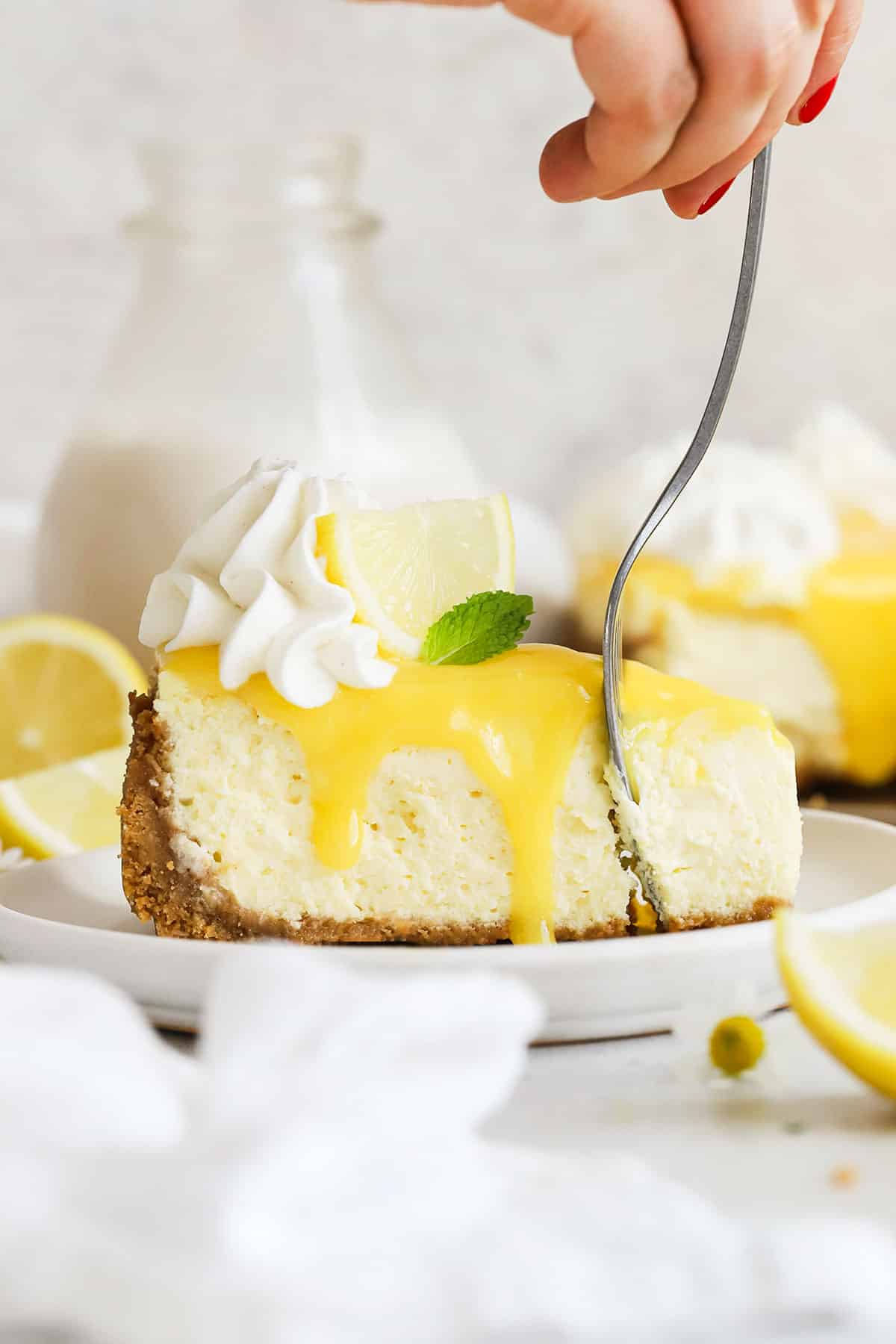 a fork getting a bite from a slice of gluten-free lemon cheesecake