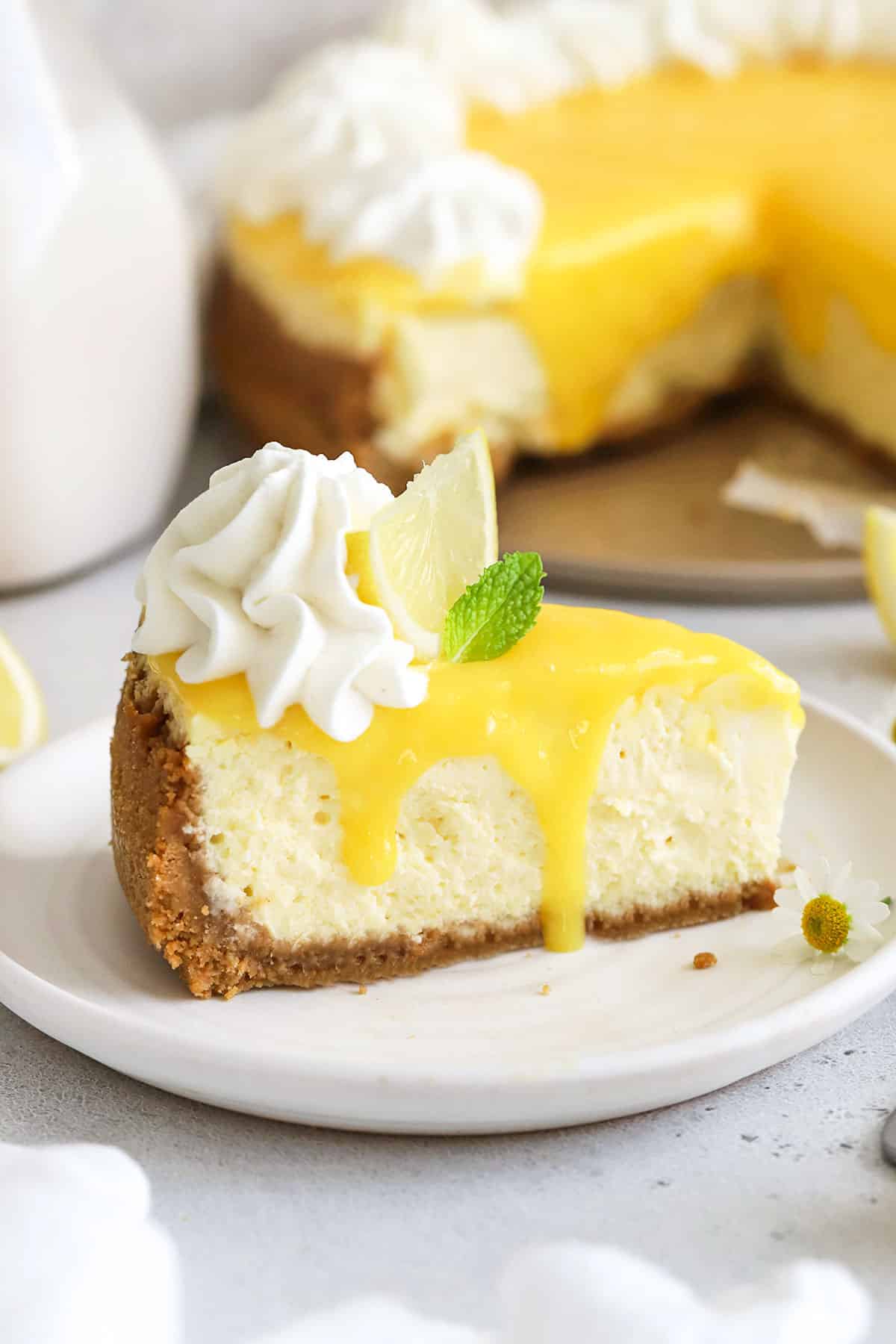 gluten-free lemon cheesecake sliced and topped with whipped cream