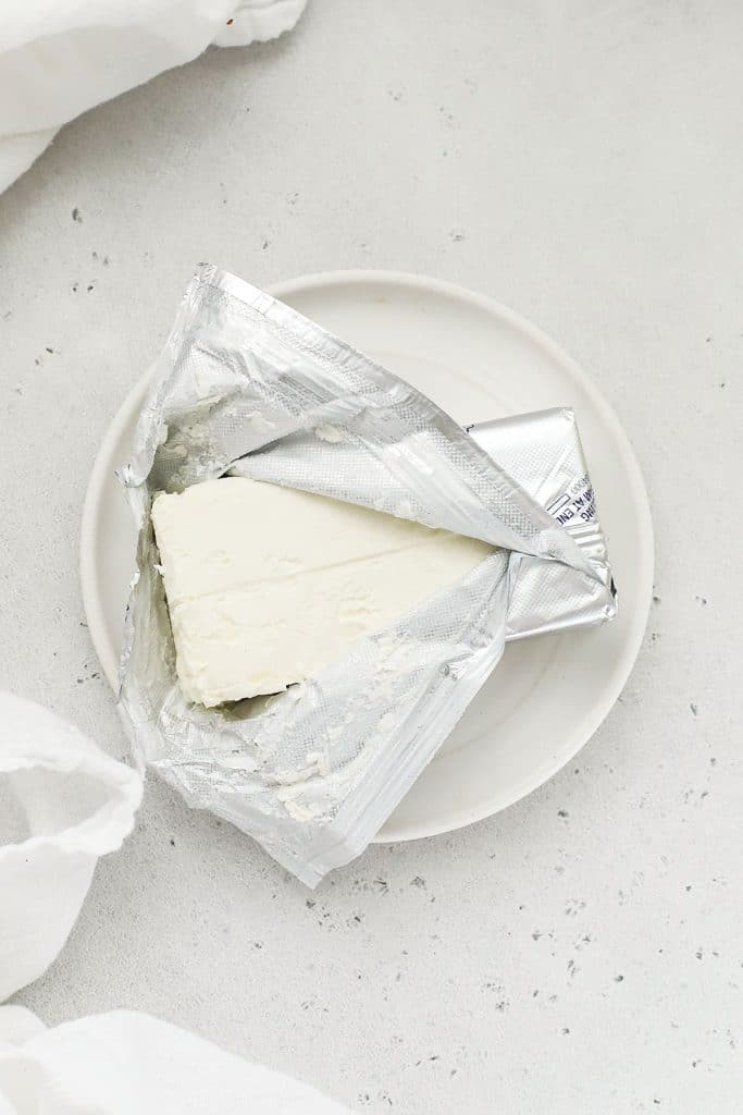 unwrapping a block of cream cheese