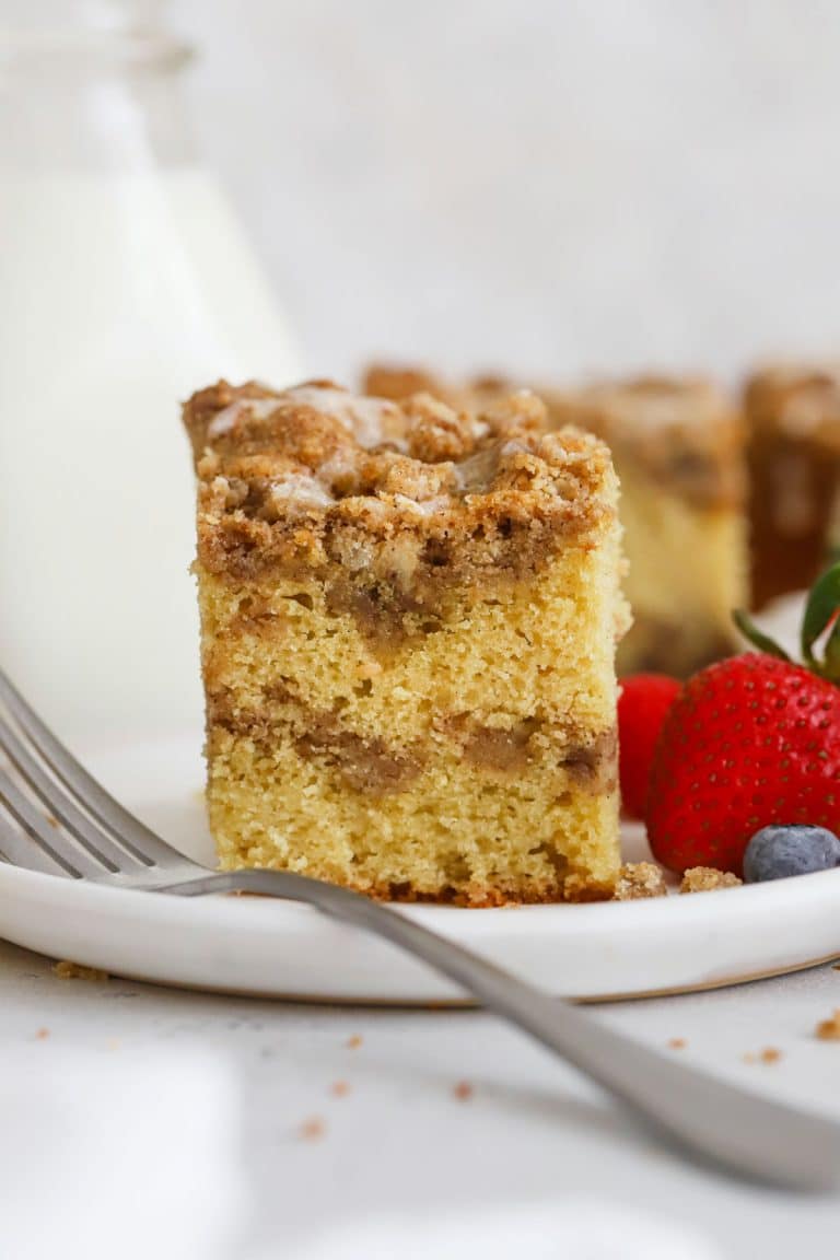 gluten-free cinnamon crumb cake on a white plate with fresh berries