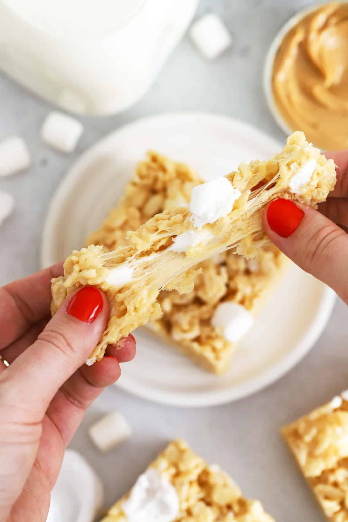 pulling a peanut butter rice krispie treat apart to show the gooey marshmallow