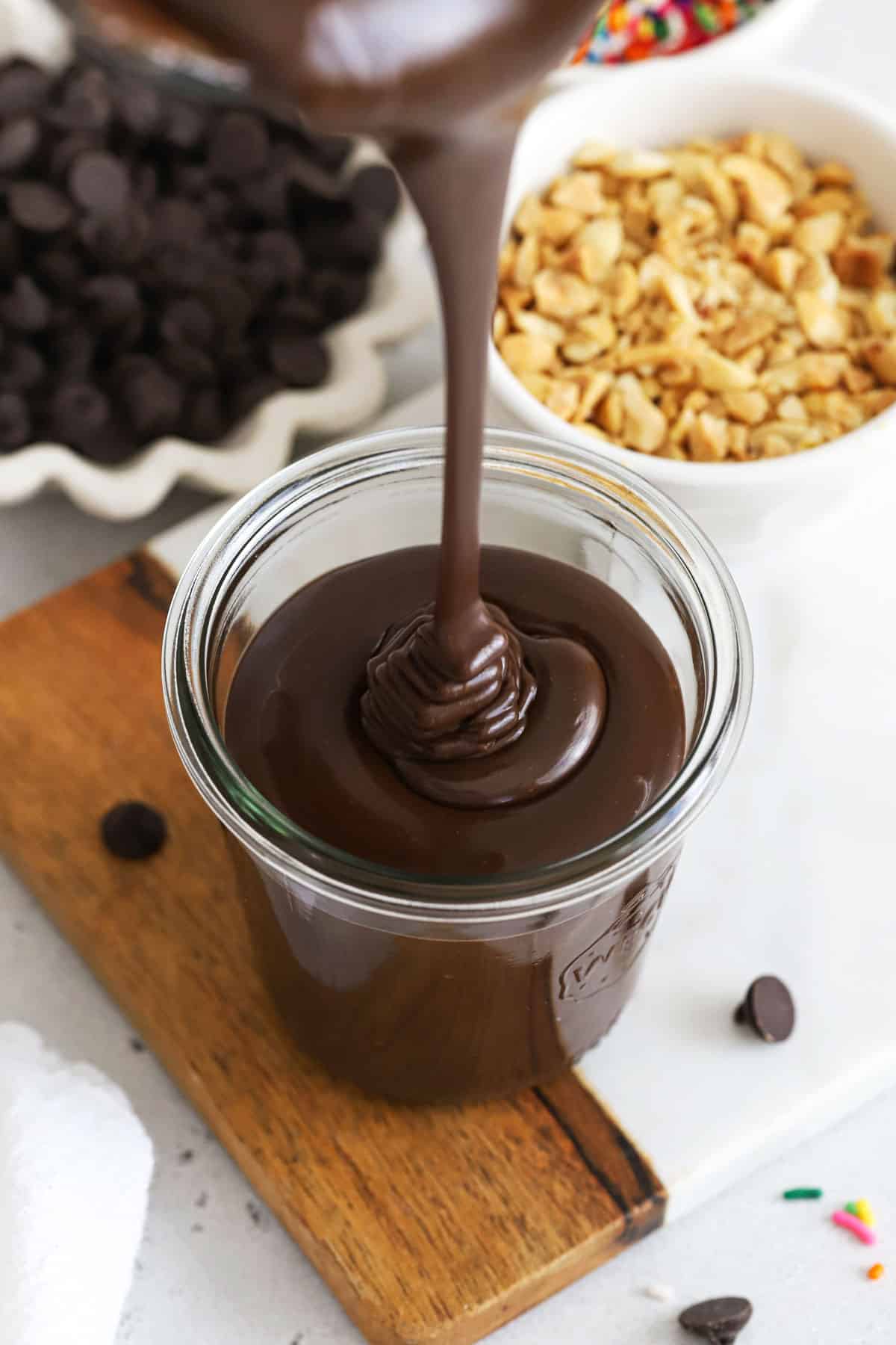 Our easy hot fudge recipe is made with NO corn syrup, but still gives you the thick, glossy texture you're looking for. To make it without corn syrup, we make our homemade hot fudge sauce with sweetened condensed milk, heavy cream, butter, chocolate, vanilla, and salt. Yum! This old-fashioned hot fudge sauce is rich, chocolatey and perfect for making hot fudge sundaes and ice cream cake. It's one of our favorite ice cream bar toppings for summer! (It's even gluten-free!)