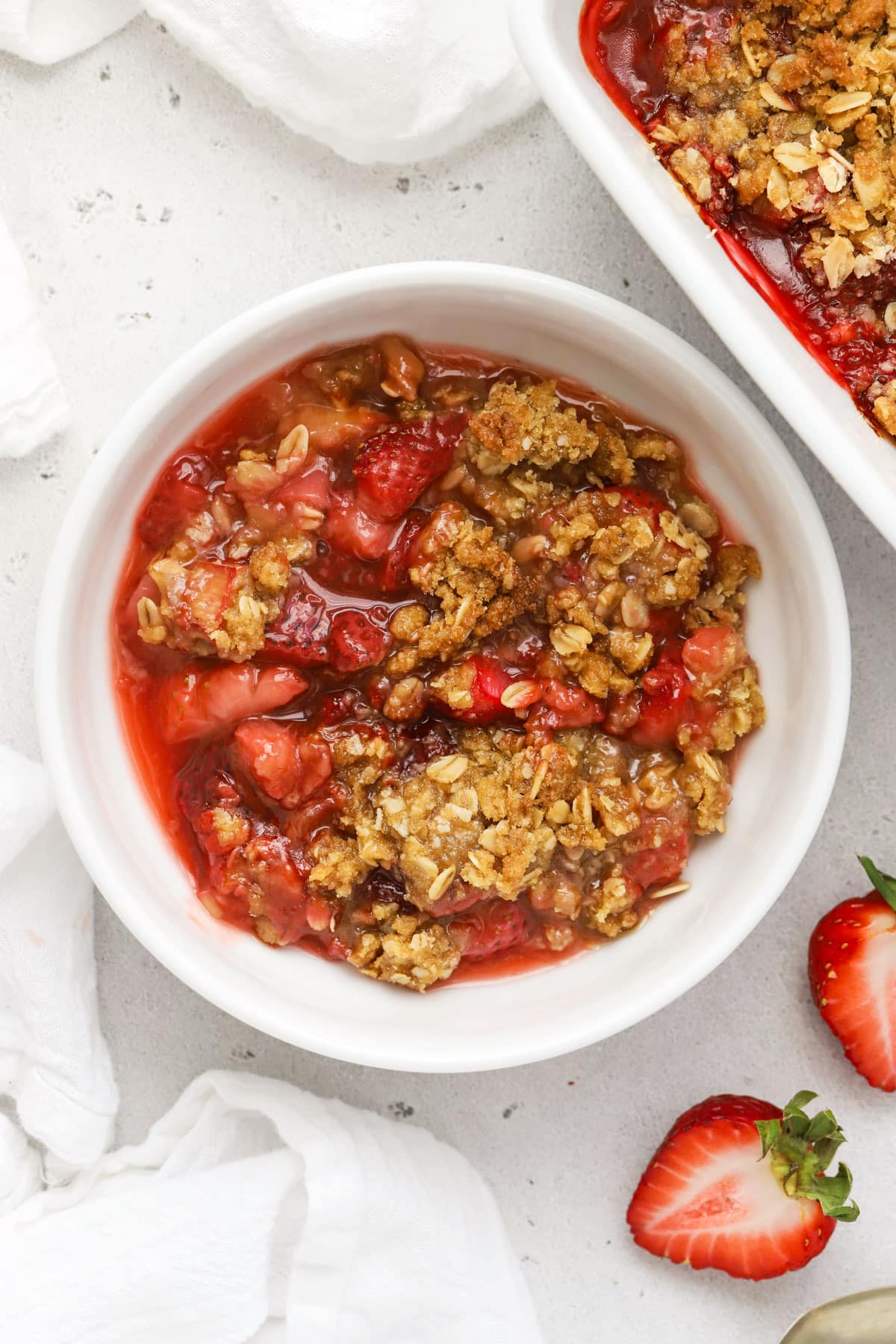 a bowl of gluten free strawberry rhubarb crisp with oat topping