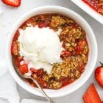 a bowl of gluten-free strawberry rhubarb crisp topped with a scoop of vanilla ice cream