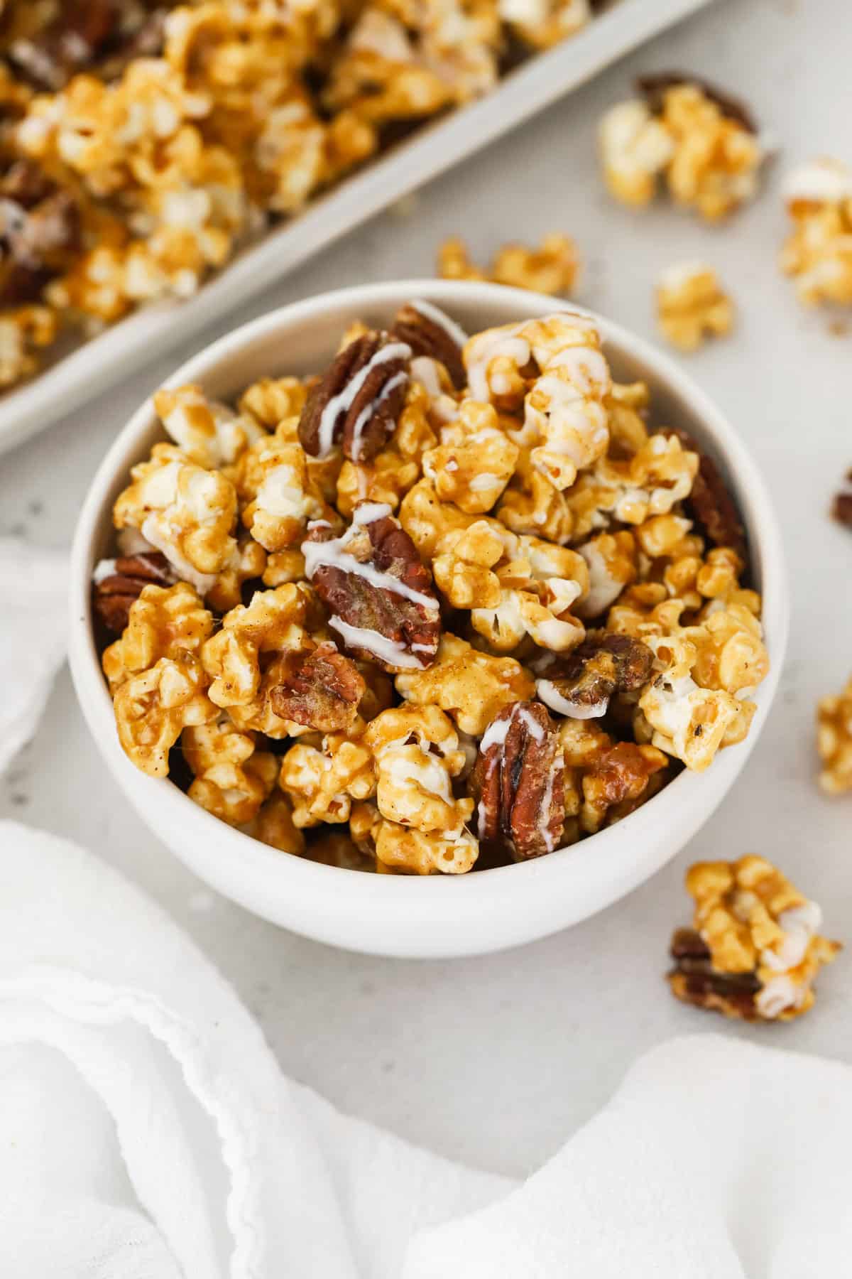 Bowl of cinnamon pecan caramel popcorn drizzled with white chocolate