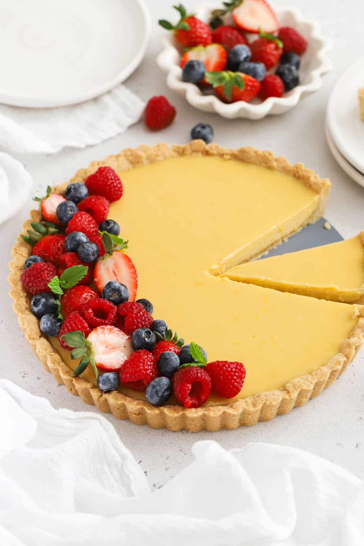 Gluten-free lemon tart with fresh berries and fresh mint leaves