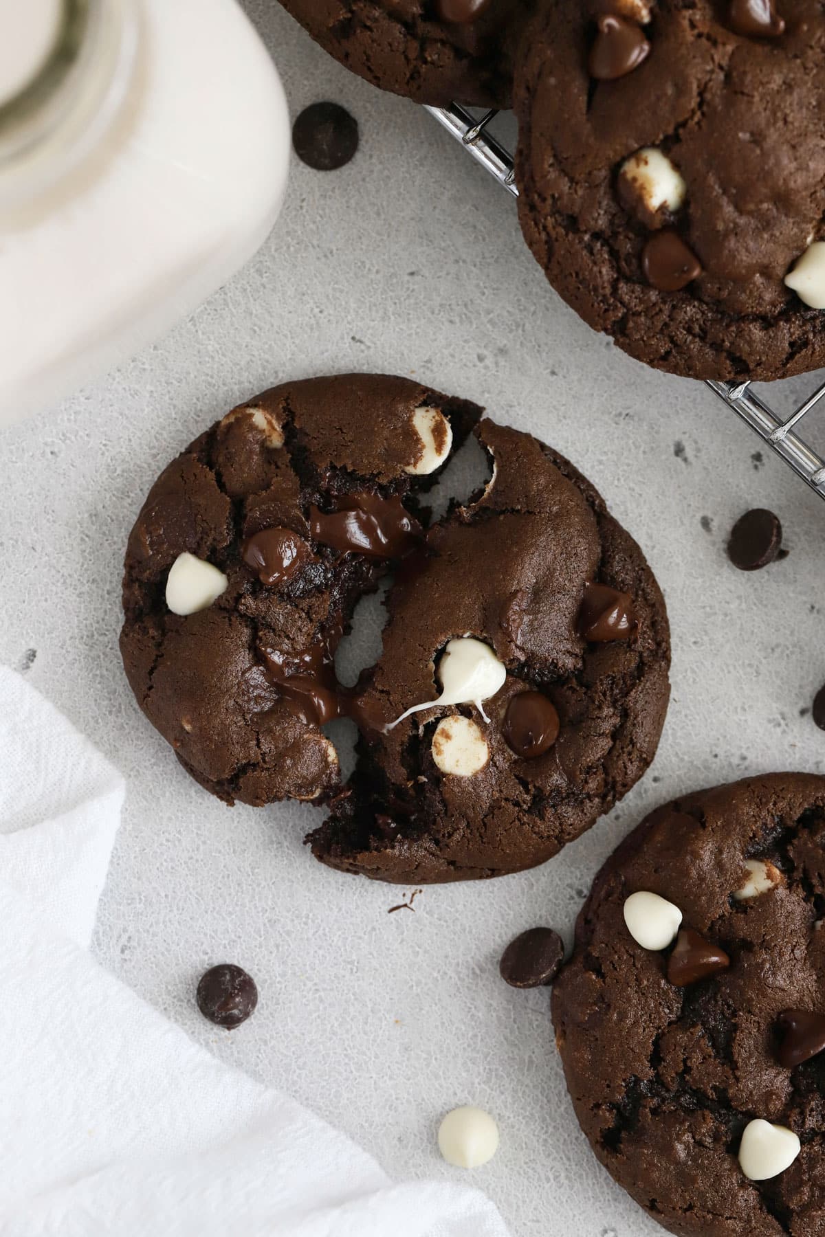 A gluten-free triple chocolate chip cookie pulled in half to show the fudgy center