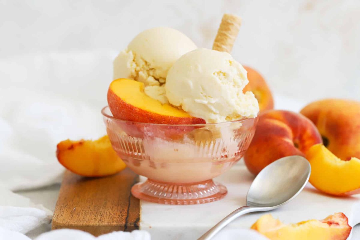 Scoops of homemade peach ice cream in a pink dessert bowl