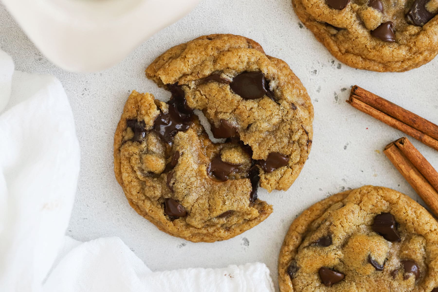 A gluten-free cinnamon chocolate chip cookie pulled apart to show the melty chocolate center