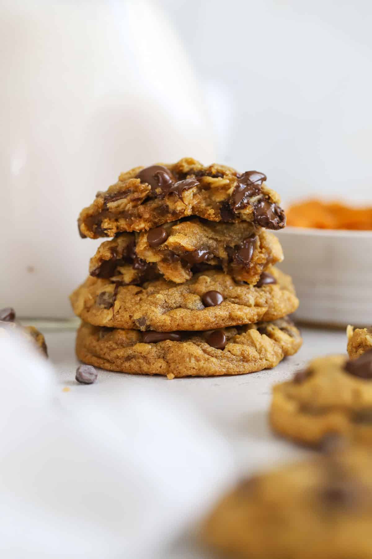 Gluten-Free Pumpkin Oatmeal Chocolate Chip Cookies stacked next to a bottle of milk